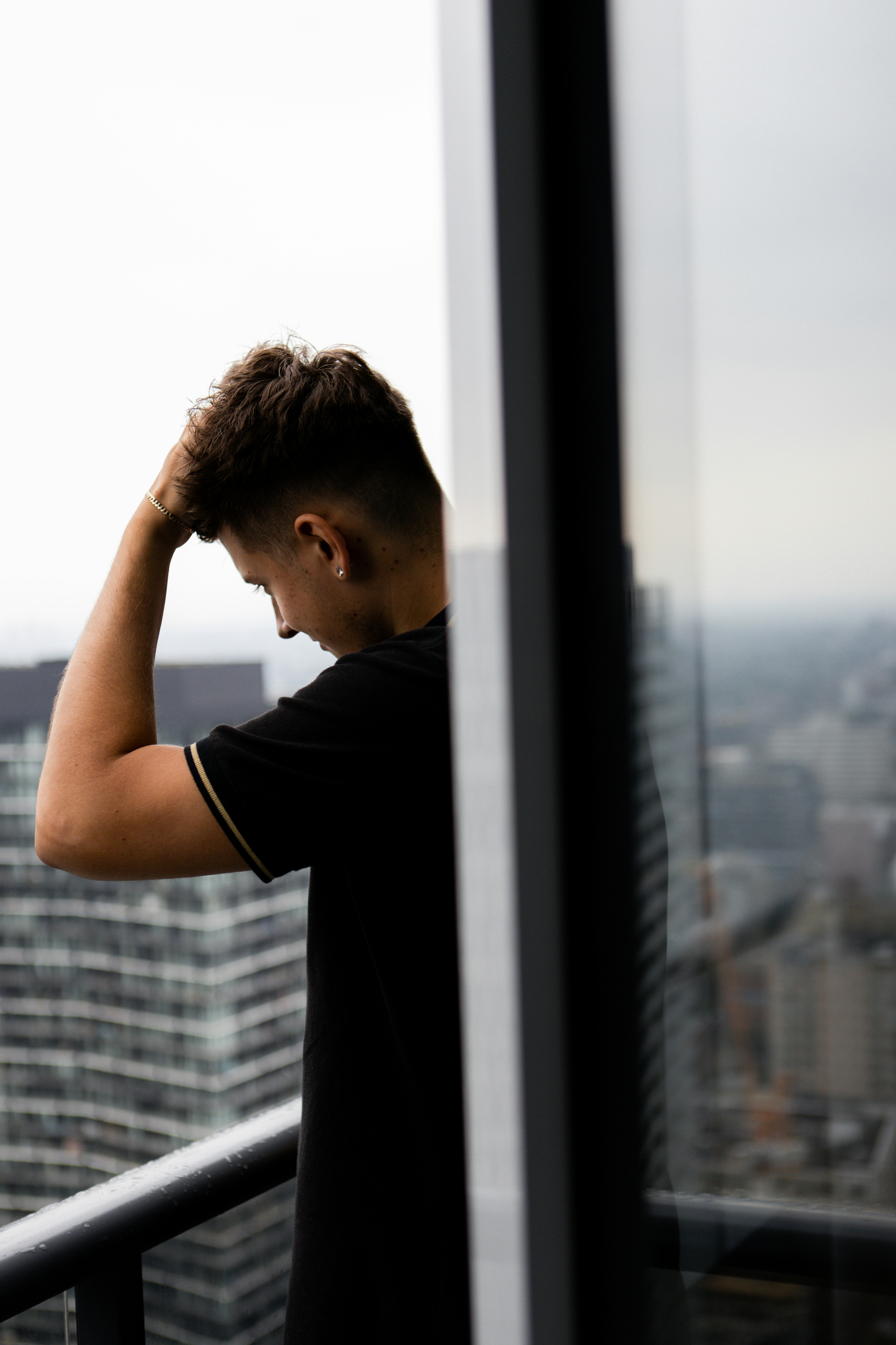 man in black t-shirt looking at the window